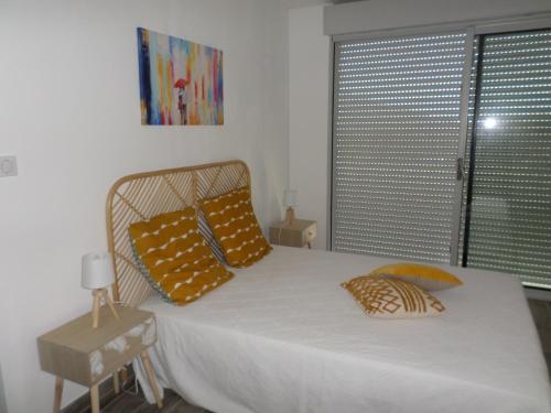 SollacaroVilla vue mer et nature route de Cigala的一间卧室配有一张带黄色枕头的床和一扇窗户