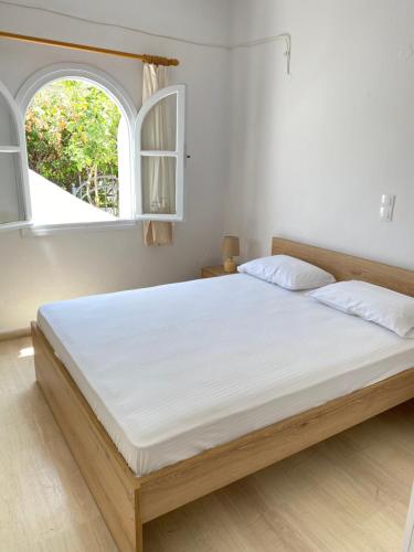 GázionBeautiful House in Front of the Sea的卧室配有一张白色大床和两个窗户