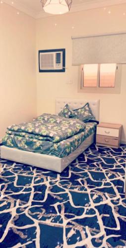 泰布克شقق العزاب الفاخرة的一间卧室配有一张床和蓝色地毯