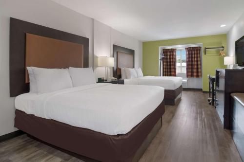 沙洛特SureStay Hotel by Best Western Shallotte的酒店客房设有两张床和电视。