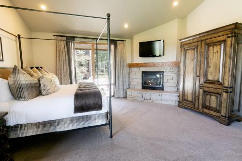 帕克城Luxury King Room with Mountain View Hotel Room的一间卧室配有一张床和一个壁炉