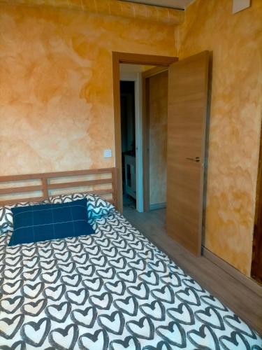 米拉弗洛迪拉希Apartamento rural的一间卧室配有一张带蓝色枕头的床和一扇门