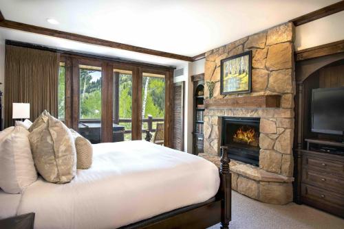 帕克城Junior King Suite Hotel Room的一间卧室配有一张床和一个石头壁炉