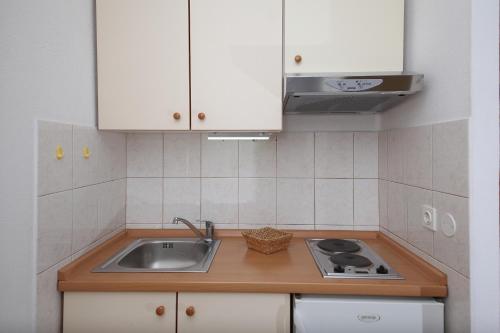 图彻皮Apartments by the sea Tucepi, Makarska - 11486的厨房配有白色橱柜和水槽
