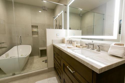 帕克城Sultan Studio Loft Hotel Room的浴室配有盥洗盆、镜子和浴缸