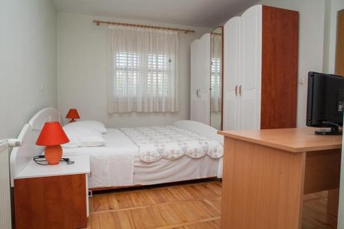 苏科尚Apartments by the sea Sukosan, Zadar - 12313的一间卧室配有一张床和一张书桌及电视