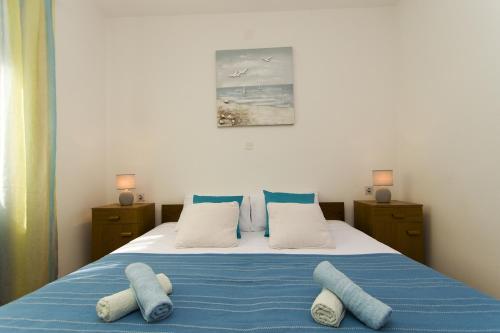 尼亚卢卡Seaside holiday house Cove Gradina, Korcula - 13803的一间卧室配有一张带蓝色床单和枕头的床。