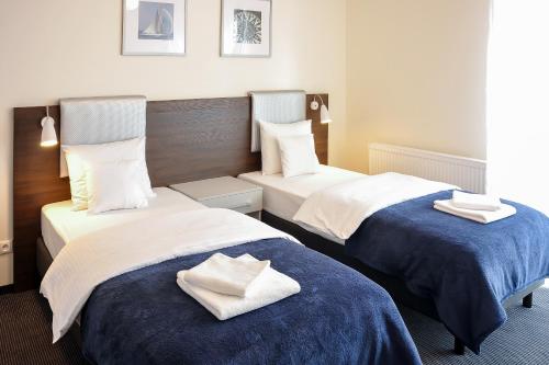 什切青斯塔卡公寓- 河滨的两张位于酒店客房的床,配有毛巾