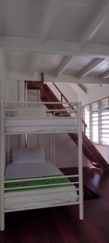 萨武萨武Gingerbread Cottage and Studio Fiji的一张白色双层床,房间内设有楼梯