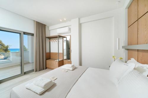 斯卡拉伯塔麦斯Elisavet Nuevo Studios & Suites的卧室设有一张白色大床和大窗户