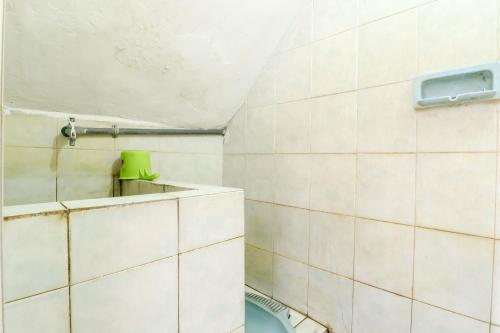 SukodonoHotel Gajah Mada的浴室设有白色瓷砖墙壁和卫生间。
