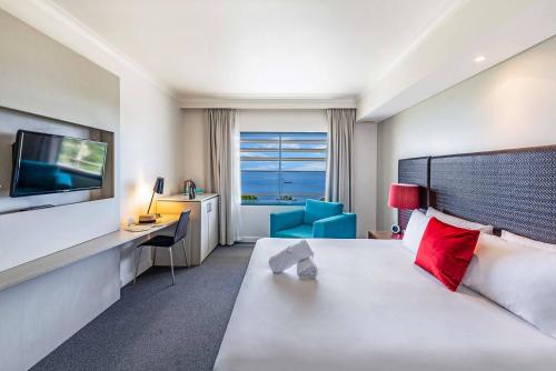 达尔文Two Private Oceanview Suites with Resort Pool的酒店客房设有一张大床和一台电视。