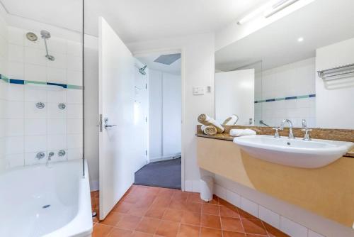 达尔文Two Private Oceanview Suites with Resort Pool的浴室配有水槽、淋浴和浴缸。