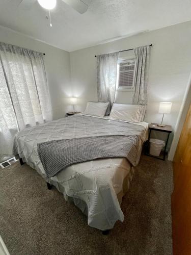 波卡特洛Cozy Home in the Heart of Pocatello的一间卧室设有一张大床和两个窗户