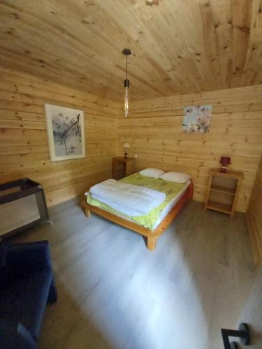 威布林Le chalet des Oisaï的小木屋内一间卧室,配有一张床