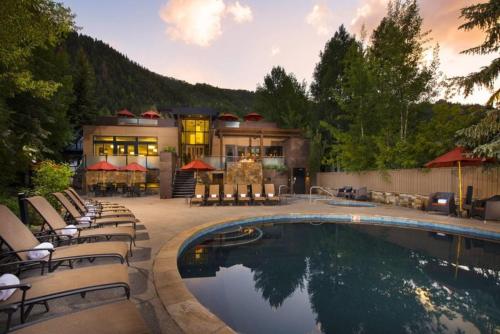 阿斯潘1 Bedroom Mountain Residence In The Heart Of Aspen With Amenities Including Heated Pool, Hot Tubs, Game Room And Spa的房屋前有游泳池的房子