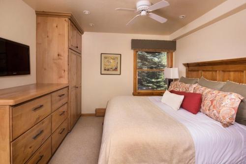 阿斯潘1 Bedroom Mountain Residence In The Heart Of Aspen With Amenities Including Heated Pool, Hot Tubs, Game Room And Spa的一间卧室配有一张大床和吊扇