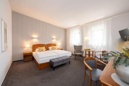 ZeithainHotel Moritz an der Elbe的酒店客房配有一张床铺和一张桌子。