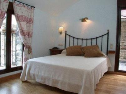 托尔拉拉塞尔别墅酒店的一间卧室配有一张带白色床单和窗户的床。