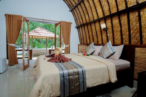 吉利特拉旺安Warna Beach Hotel的一间卧室设有两张床和大窗户