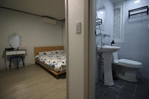 首尔Bunk Backpackers Guesthouse的一间带床、水槽和卫生间的浴室