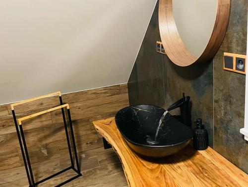 波罗瓦拉达Roubenka Meandra - studio 32m2的浴室内木制柜台上的黑水槽