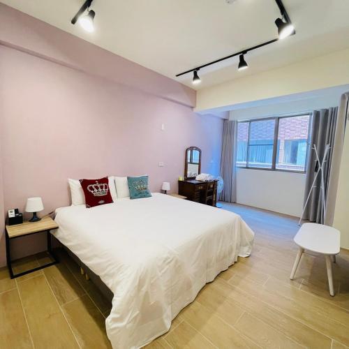 台南唐揚十二街的卧室设有一张白色大床和一扇窗户。
