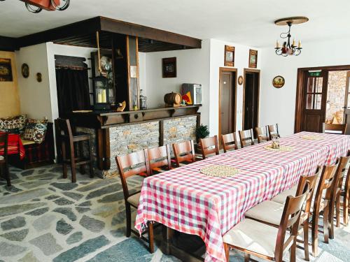 莱什顿Rimovata Kashta Guest House的一间带桌椅和壁炉的用餐室