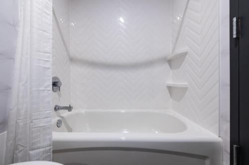 纽瓦克Holiday Inn Newark International Airport的白色的浴室设有浴缸和卫生间。
