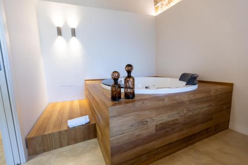 巴勒莫Bastione Spasimo Boutique Hotel的一间带浴缸的浴室,位于木柜台上