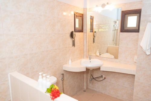 苏梅岛Satva Samui Yoga and Wellness Resort的一间带水槽、浴缸和镜子的浴室