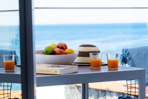 普萨克迪亚Aiora Suites by Booking Kottas的一张桌子,上面放着一碗水果和一碗果汁