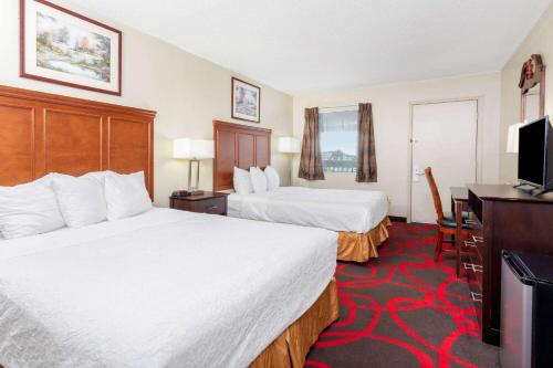 里士满Travelodge by Wyndham Richmond IN的酒店客房设有两张床和一台平面电视。