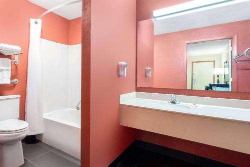 里士满Travelodge by Wyndham Richmond IN的一间带水槽、卫生间和镜子的浴室
