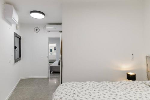 特拉维夫Unique Urban Villa - Live Local with Style的一间白色卧室,配有一张床和一个走廊