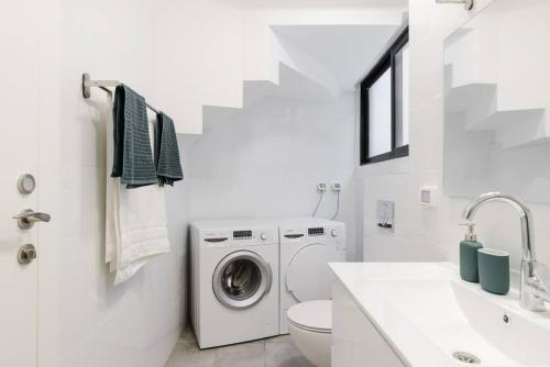 特拉维夫Unique Urban Villa - Live Local with Style的白色的浴室设有洗衣机和水槽。