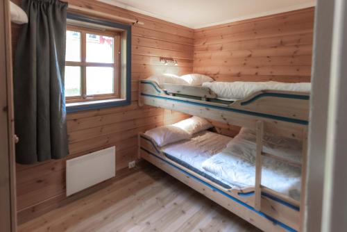 特吕西尔Bakkebyvegen 1D的木制客房设有两张双层床和窗户。