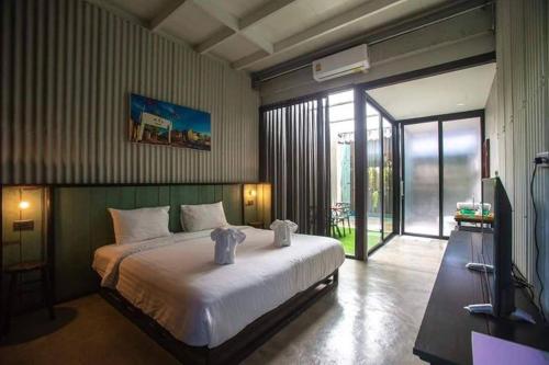 董里绿树安睡空间旅舍的卧室配有一张白色大床和滑动玻璃门