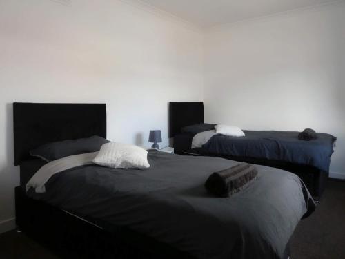 邓弗里斯Dumfries Apartment的一间卧室设有两张床和白色的墙壁