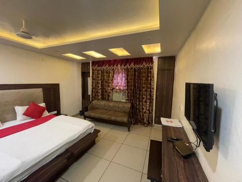 贾姆穆Hotel Himgiri的一间卧室配有一张床、一张沙发和一台电视