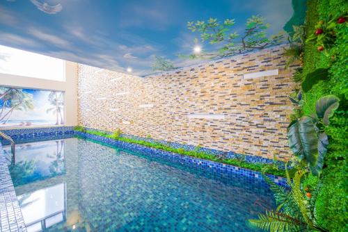 岘港Golden Star Hotel & Apartment by THG的砖墙房间的游泳池