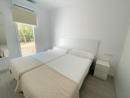 埃斯卡洛Can Valonsadero, Villa con Piscina的白色的卧室设有一张大床和一个窗户