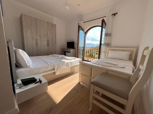 BurreliBujtina Celiku的一间卧室配有一张床和一张带窗户的书桌