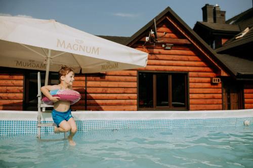 齐斯纳Solny - Resort w Bieszczadach的水中一个男孩,在游泳池里穿着救生圈