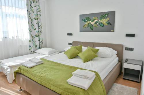 Donji KraljevecHOSTEL GREEN的一间卧室配有一张带绿色和白色枕头的大床