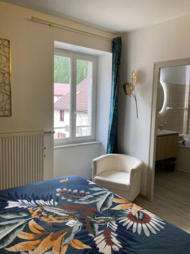 Villard-Saint-SauveurJoly Saint Sauveur的卧室配有床、椅子和窗户。