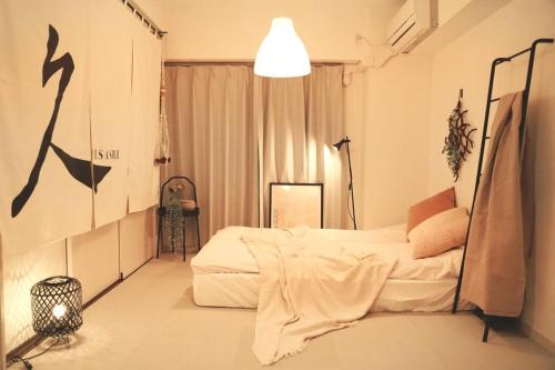 Minami-sotoborichō久Hisashi大須観音店民泊的一间卧室配有一张床和一盏灯