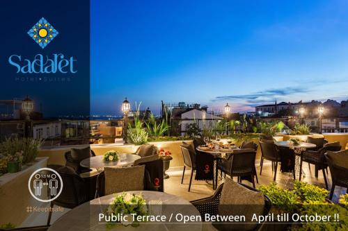 伊斯坦布尔Sadaret Hotel&Suites Istanbul -Best Group Hotels的晚上在阳台上设有桌椅的餐厅