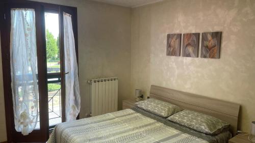 龙基德伊莱焦纳里Rose e Frutta ristrutturato con parcheggio的一间卧室设有一张床和一个窗口