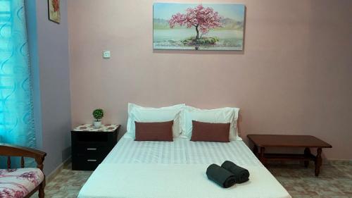 Kampong TamanSeri Idaman Guest House (Pasir Mas)的卧室配有白色的床,上面有树